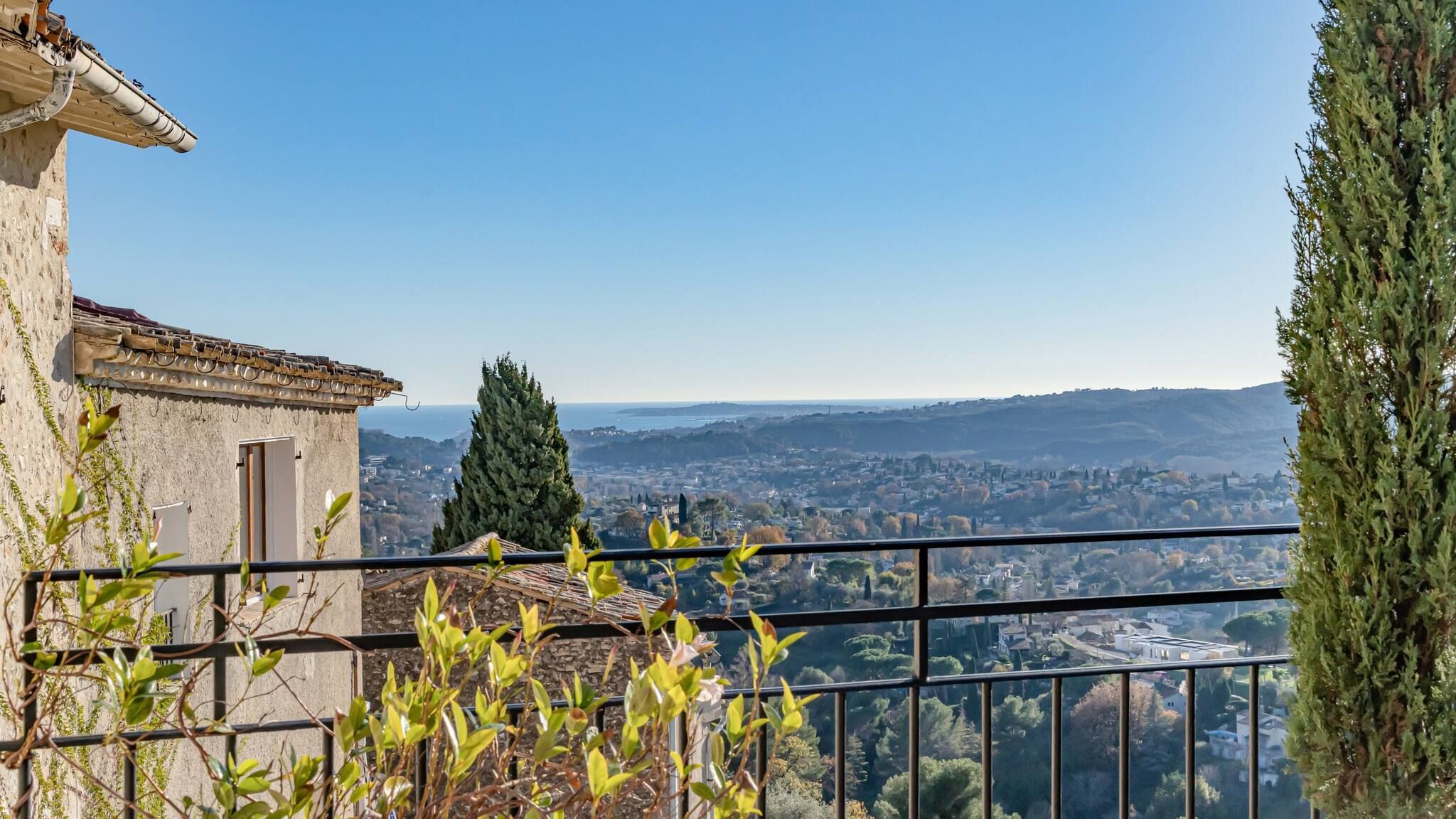 Uma varanda com vista para uma cidade e colinas ao longe.