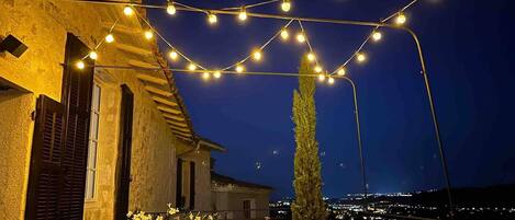 Un edificio con luces colgantes y plantas en macetas.
