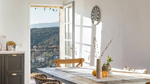 A dining area with a table, chairs, a vase with flowers, and a dartboard.