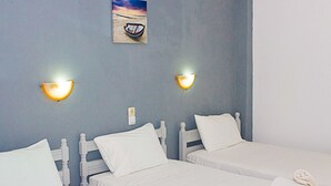 A room with two single beds, white bedding, and a wall-mounted picture of a boat on a beach. - La Pensione Skiathos (Skiathos)