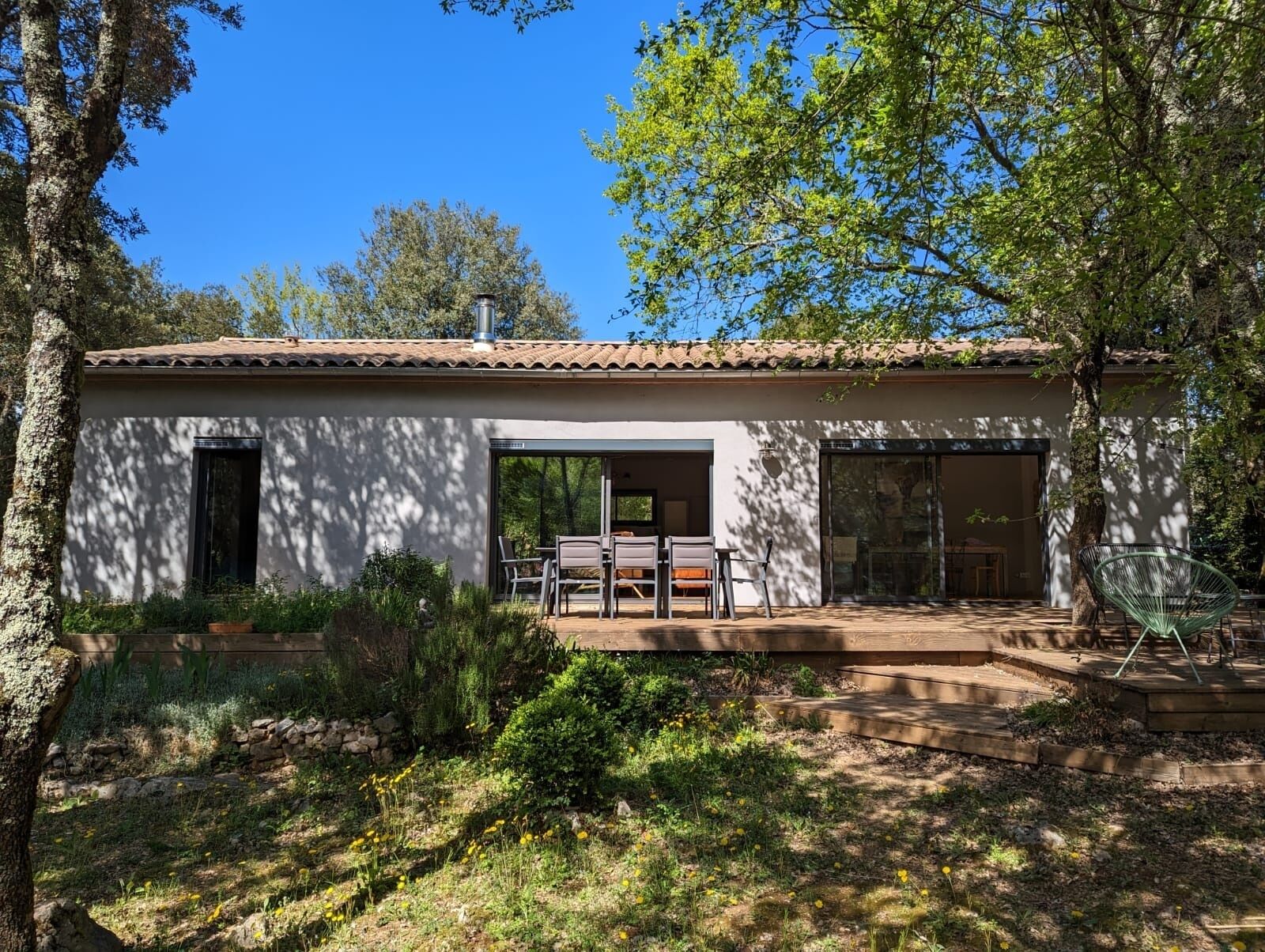 Une maison moderne dotée d’un patio, d’un coin repas et d’un garage.