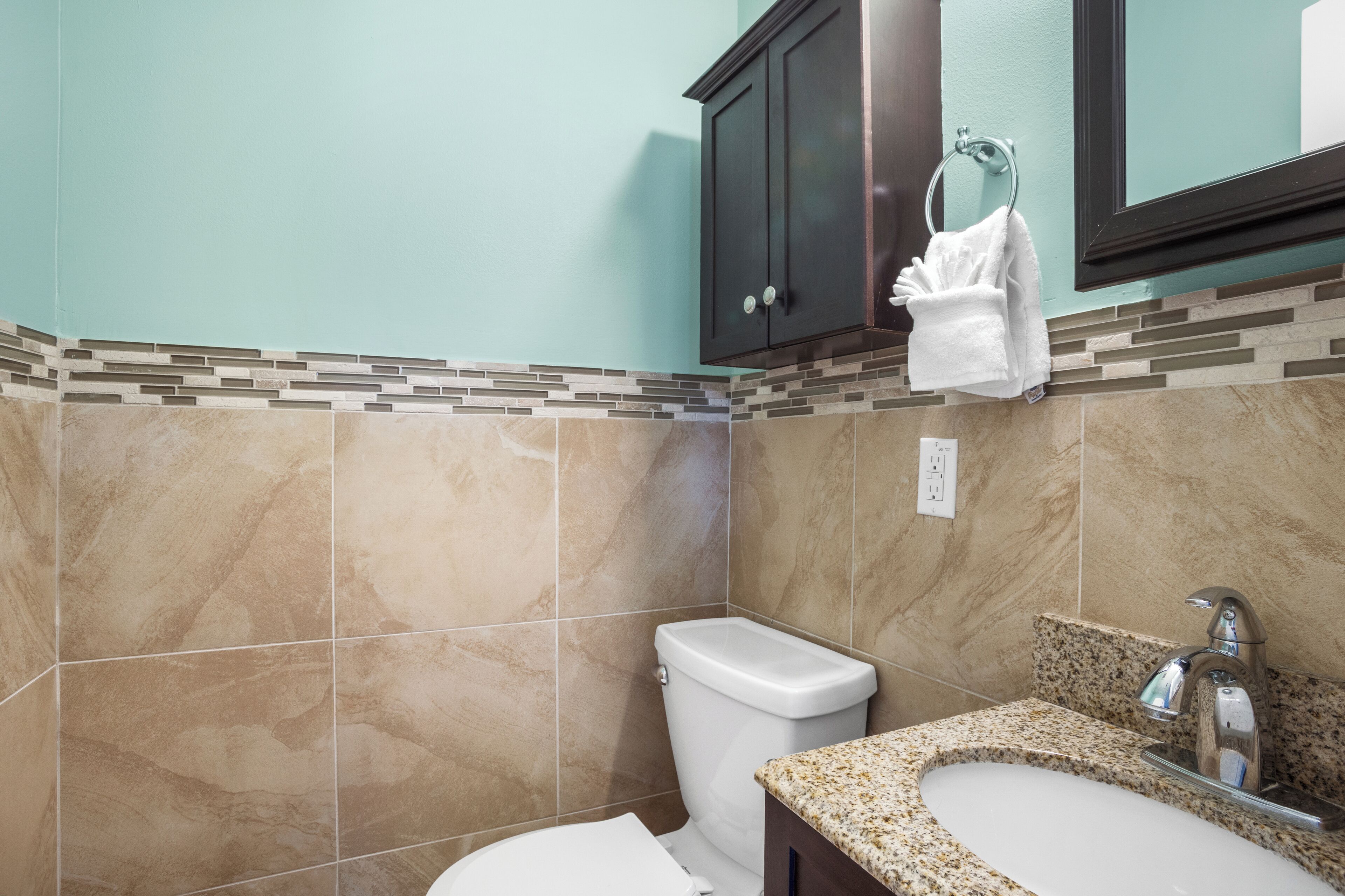 Un baño con inodoro, lavamanos y armario.