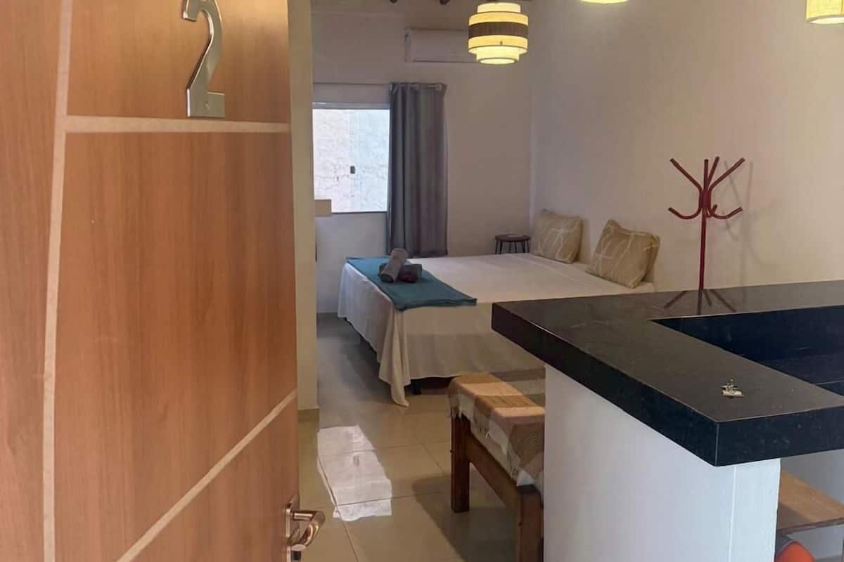 Een kamer met een bed, een bureau en een badkamer.