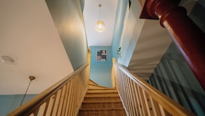 Una escalera de madera con una lámpara y un tablón de anuncios.