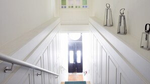 A staircase with white walls, a green carpet, and a view of a room with a door at the top. - Cozy and Modern Apartment in Porto (Porto)