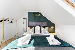 A bedroom with a bed, a hanging plant, a bedside table with a lamp, and a clothing rack. - A Boutique 4 bed House in Bath - Parking (Bath)