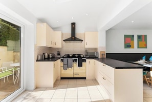 A modern kitchen with a central island, a stove, and a microwave. - A Boutique 4 bed House in Bath - Parking (Bath)