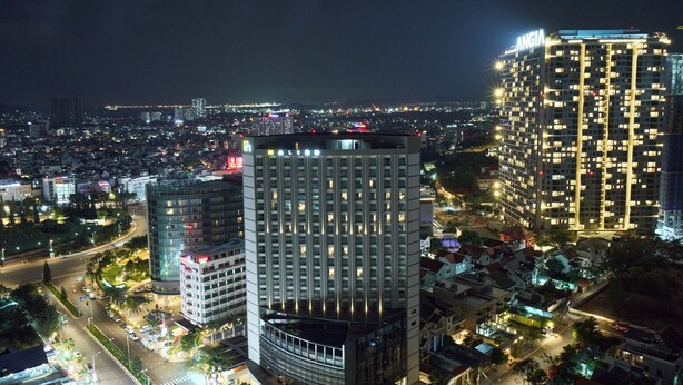 A high-rise building with multiple floors, a prominent "ANGIA" sign on top, and a well-lit facade.