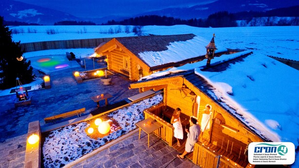 A wooden cabin with a sauna, outdoor seating, and a view of a snowy landscape. - Mountain Residence CLARA (Brunico)