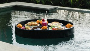 A floating dining platform with various dishes and drinks. - Arindama Villa Ubud by Dhananjaya Hospitality (Sebatu)