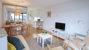 A modern living room with a dining area, a kitchen, and a TV. - Studio by the Beach With Sea View (Koksijde)