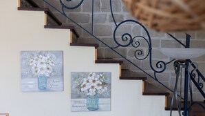 A staircase with a blue metal railing and a wall with two framed floral paintings. - Villa Stephanie with pool (Marina di Ragusa)