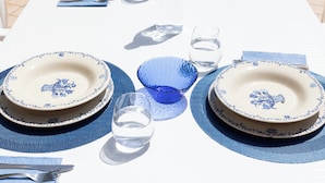 A table set with blue and white plates, a blue glass, and clear glasses. - Villa Stephanie with pool (Marina di Ragusa)