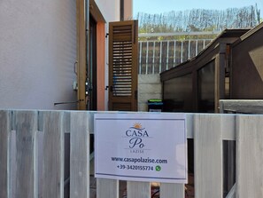 A wooden fence with a sign for CASA PO LAZISE, including a website and phone number.