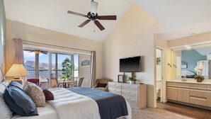 A bedroom with a bed, a desk, a chair, a television, and a bathroom mirror. - Meadow Brook Resort Getaway (Branson)