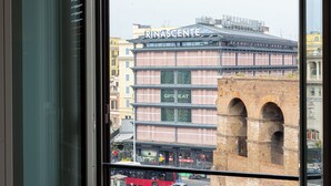 A building with the sign "RINASCENTE" and a brick structure with arches in the background. - Amazing Piazza Fiume (Roma)