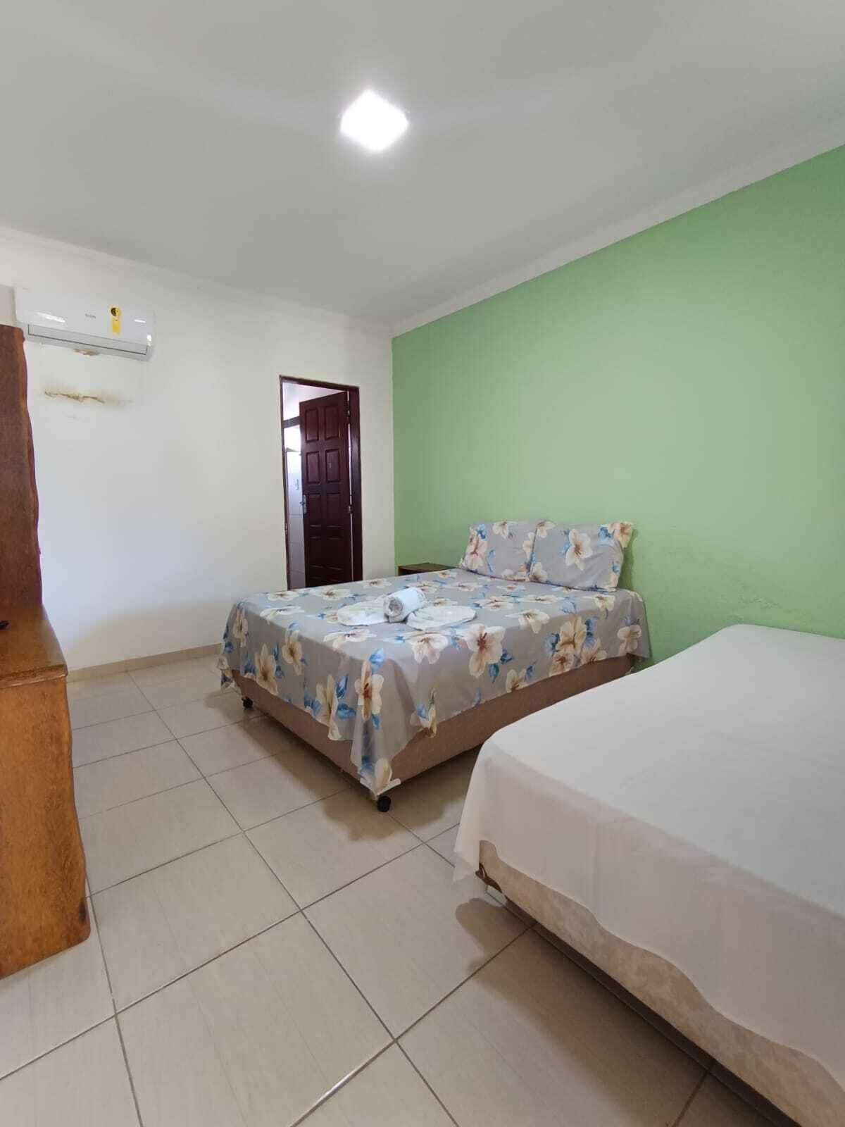 Ein Schlafzimmer mit Bett, Kommode und Tür.