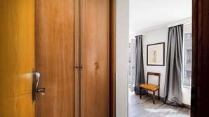 A wooden door with a modern handle, a chair, and a framed picture on the wall. - Charming Apartement- 1br-4p- Geneve (Geneva)