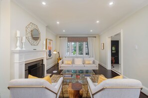 A living room with a fireplace, a sofa, a coffee table, and a view of the outdoors. - YOUR OASIS IN THE CITY (Toronto)