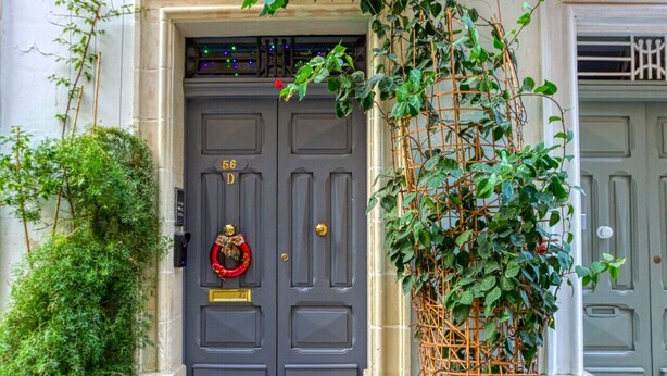 A grey double door with a red wreath and a number plaque. - Valletta in Style beautiful apartment (IL-BELT VALLETTA)