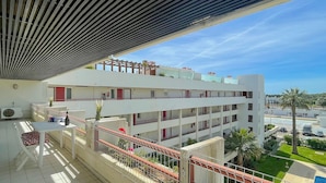 A multi-story building with balconies, outdoor seating, and a clear view of the surrounding area. - Poolside Bliss T1 Hsrentals Vilamarina (Loulé)