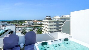 A balcony with a hot tub, two purple chairs, and a view of the city and sea. - Penthouse Triplex com Jacuzzi T3 Hsrentals Vilama (Loulé)