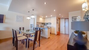 A modern kitchen with white cabinets, a central island, and pendant lighting. - Vista Marina Exclusiva T1 Hsrentals Vilamarina (Loulé)