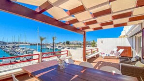 A terrace with a view of a marina, outdoor seating, and a table with a glass. - Que Sonho Vista Marina T2 Hsrentals Vilamarina (Loulé)