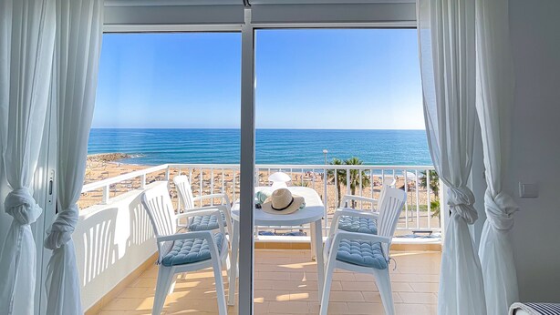 Un balcón con vista a la playa y al océano.