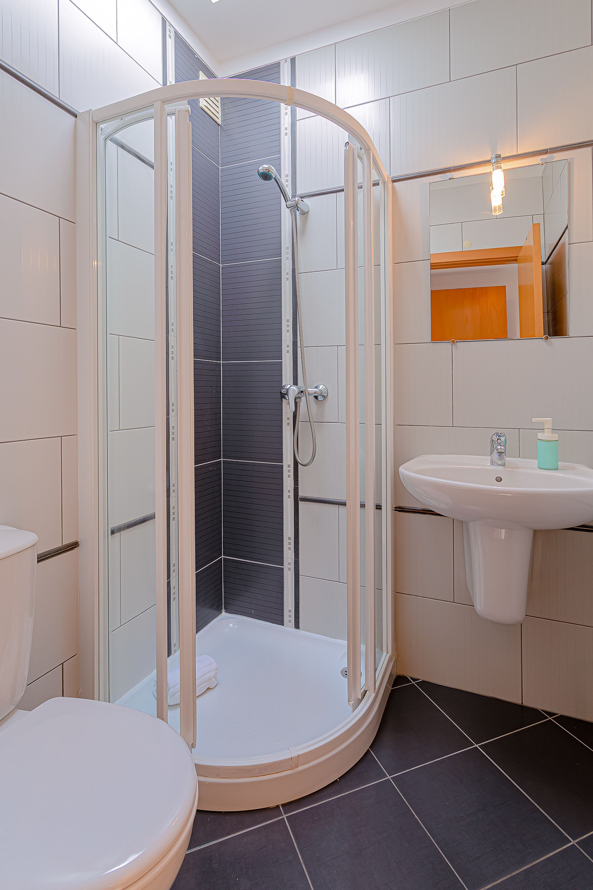 Ein Badezimmer mit Duschkabine, Waschbecken und Toilette.