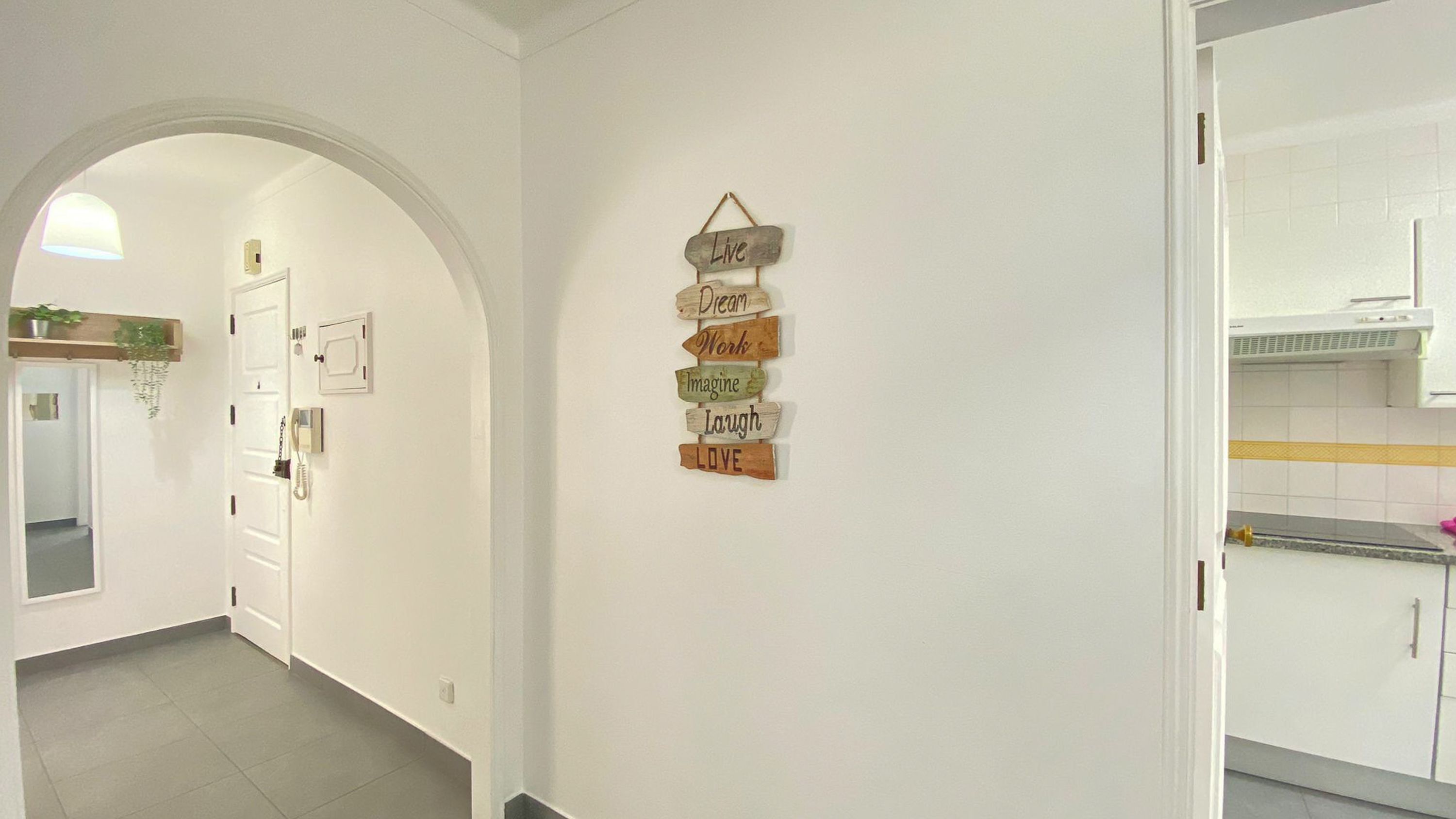 A hallway with a wall-mounted sign featuring motivational phrases.
