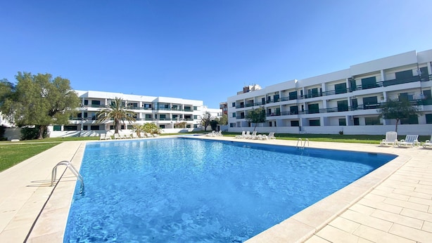 A rectangular swimming pool with clear blue water, surrounded by a tiled deck. - Yes Vilamoura Central - T1 Aldeia do Mar (Loulé)