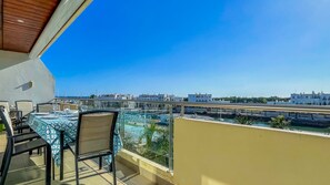 A balcony with a table and chairs, overlooking a marina and cityscape. - Aquamar Sunset T2 Hsrentals Marina Vilamoura (Loulé)