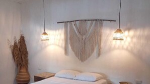 A bedroom with a wooden bed, two bedside tables, a macrame wall hanging, and hanging lamps. - MISTICA Tayrona Cinto (Santa Marta)