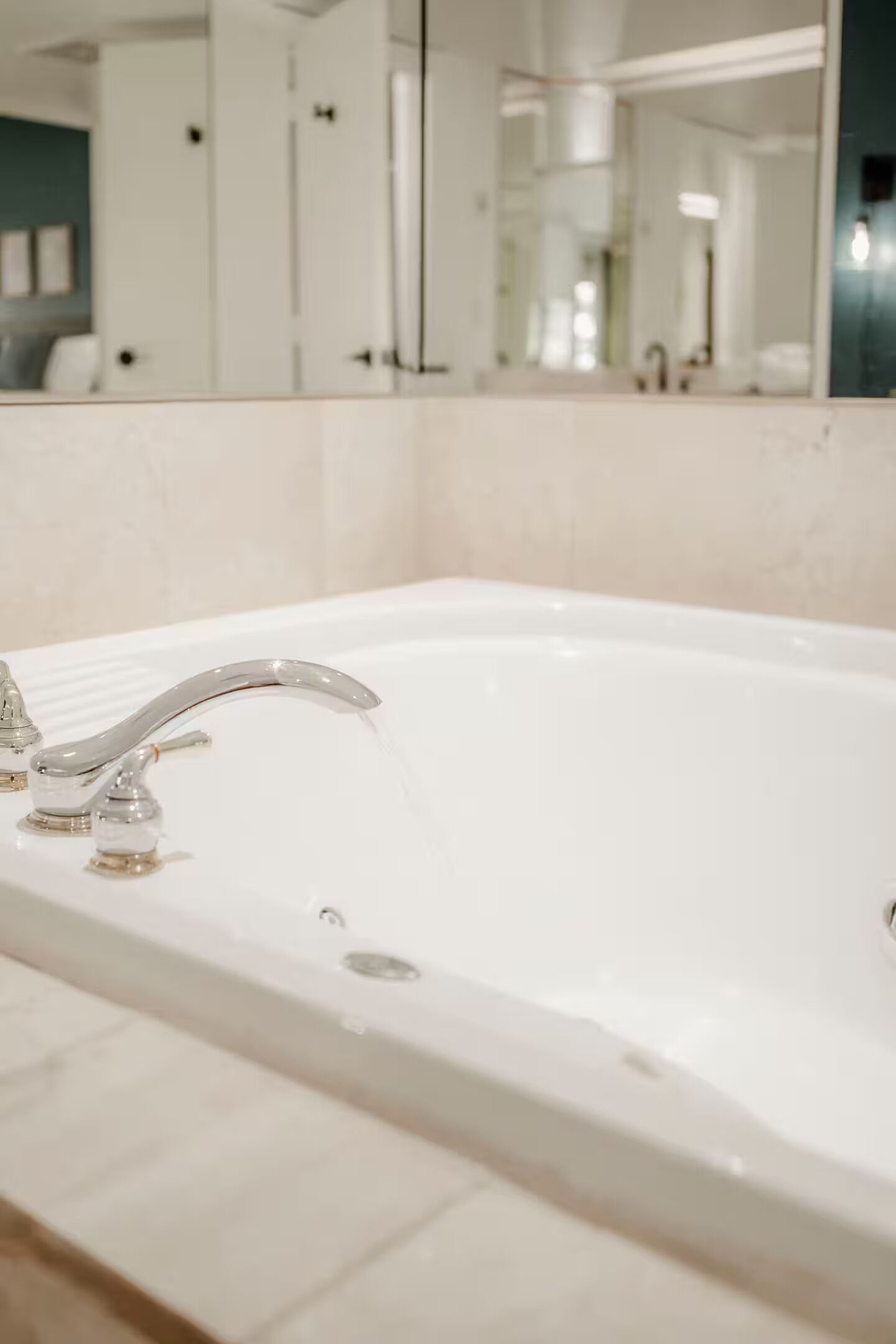 Une salle de bain avec un lavabo blanc, un miroir et une porte au fond.