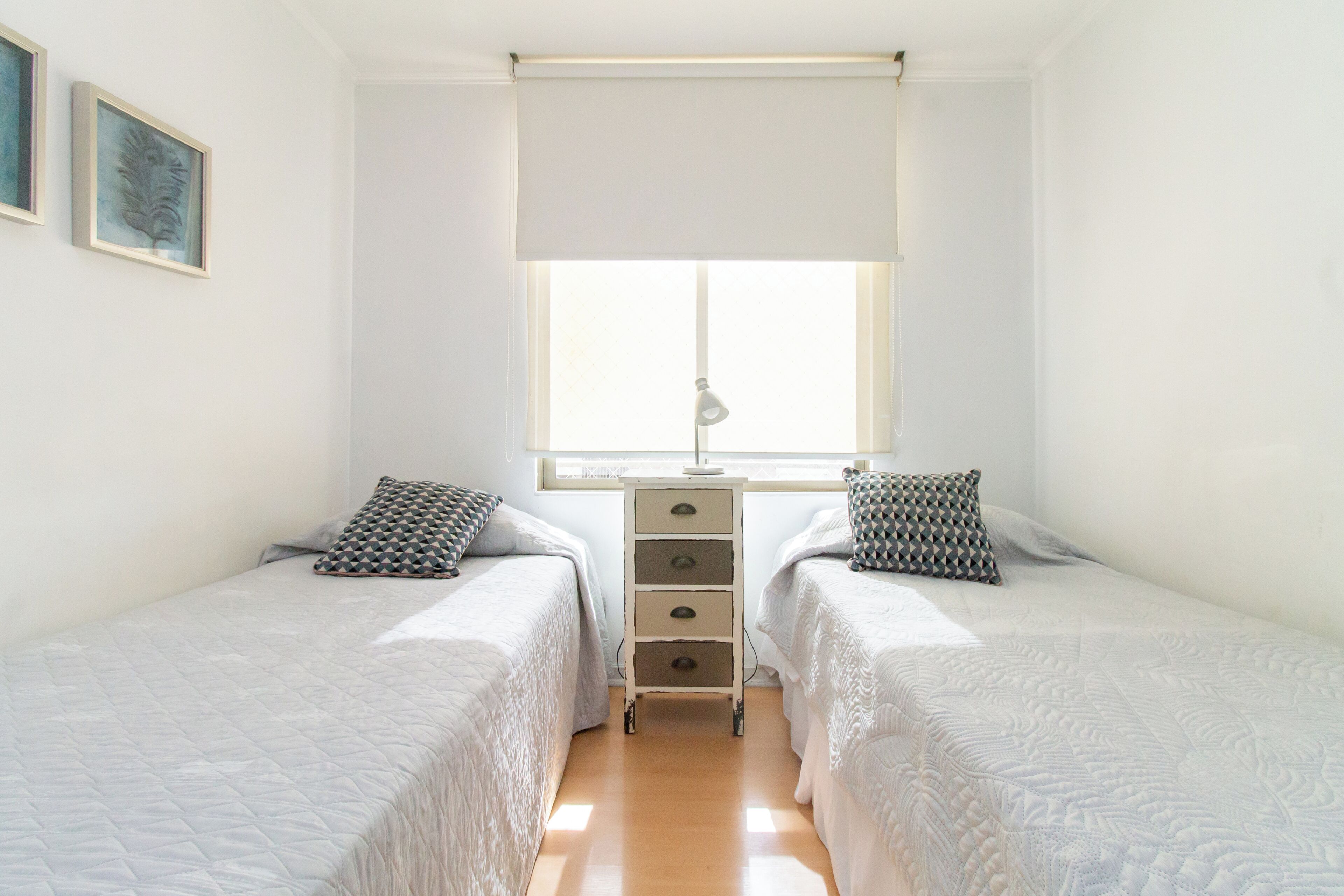 Un dormitorio con dos camas, un escritorio y una ventana.