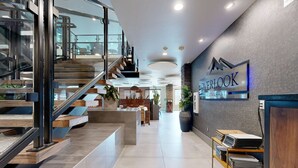 Un intérieur moderne comprenant un comptoir d’accueil, un escalier et une enseigne indiquant le « Restaurant Overlook ».