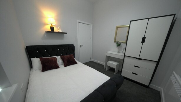 Une chambre d’hôtel comprenant un lit, un bureau, une chaise et une armoire.