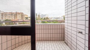 Pieni, laatoitettu parveke, jolta avautuu näkymä kauempana sijaitseviin rakennuksiin.