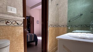 A bathroom with a toilet, a sink, and a shower area. - La Casa del Árbol - Oaxaca Historic Center (Oaxaca de Juárez)
