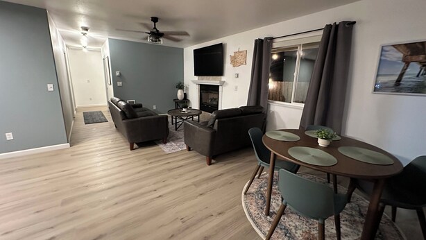 A modern living room with a fireplace, a dining area with a round table, and a seating arrangement. - 3BR 1.5Ba - Private Hot Tub & Game Room!! 2 Pets stay free! (Ocean Shores)