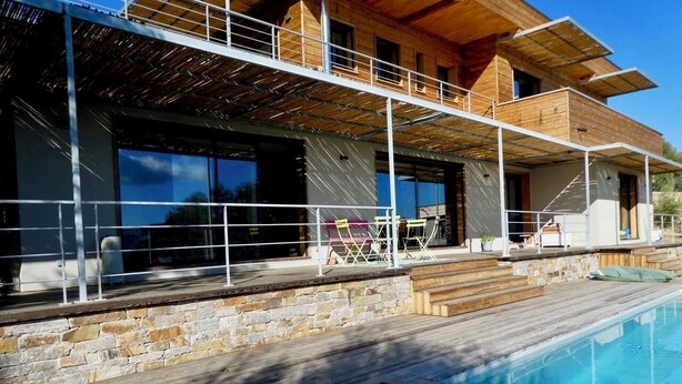 A modern house with a swimming pool, stone walls, and wooden deck. - Charming house in the greenery - Downtown Porto-Vecchio (Porto-Vecchio)