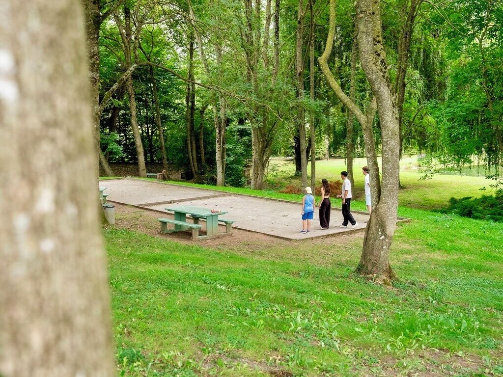 Un parc avec des tables de pique-nique et une pelouse.