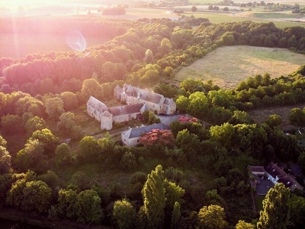 An aerial view of a large estate with multiple buildings, surrounded by dense greenery and fields. - Domaine de Fontenay (Fontenay-sur-Vègre)