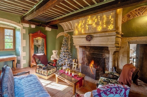 Una habitación acogedora con chimenea, un árbol de Navidad y una estatua de un oso.