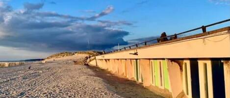 A beach with a row of buildings along the shore.
