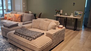 Ein Wohnzimmer mit einer Couch, einer gemusterten Decke und Blick auf eine verschneite Landschaft.