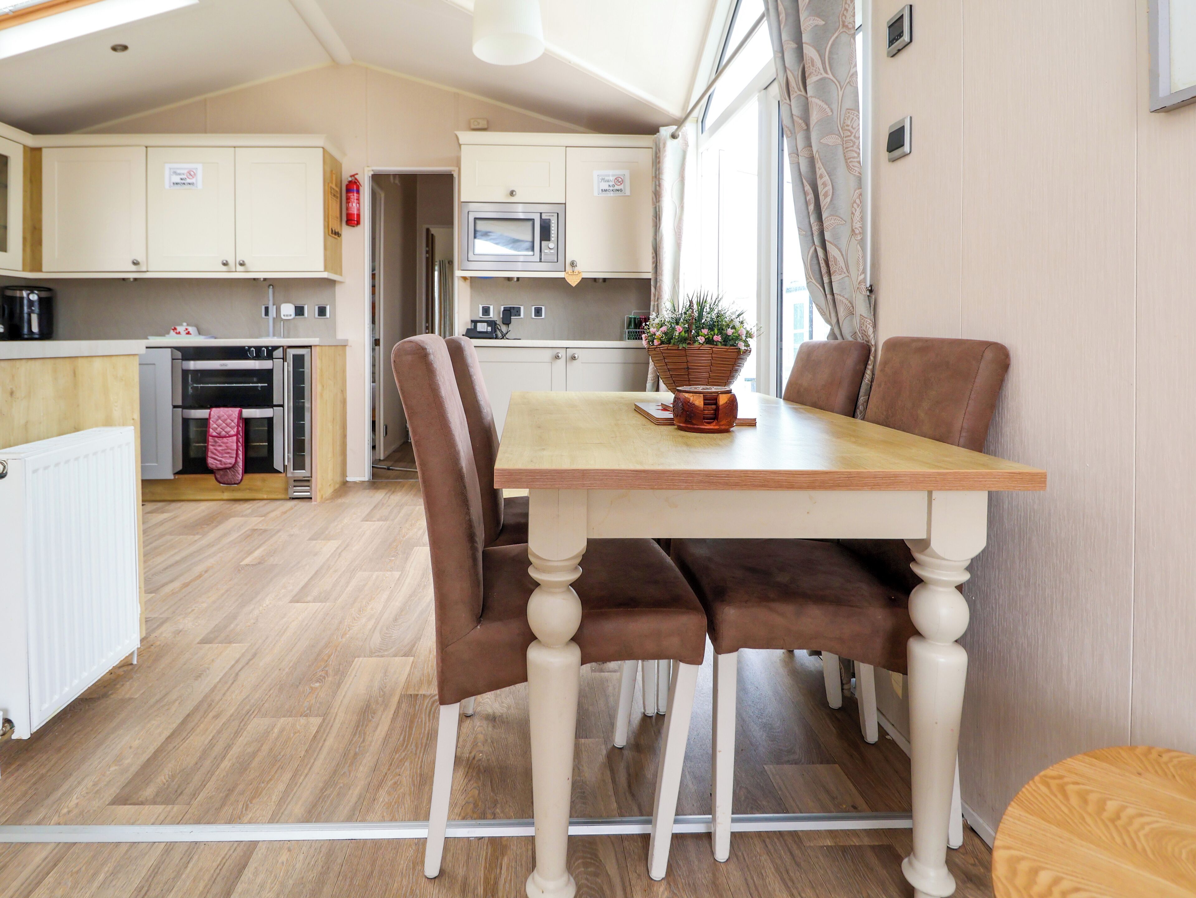 A compact kitchen with a microwave, oven, and a dining area with a table and chairs.
