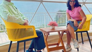 Two people seated at a table with a view of the sea.
