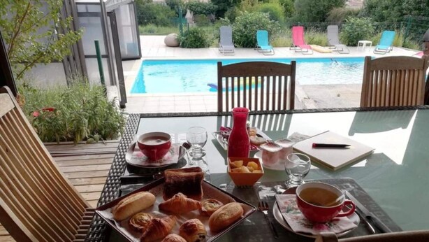 A table set for breakfast with croissants, a red cup, and a glass of water. - Chalet Zen (Peri)